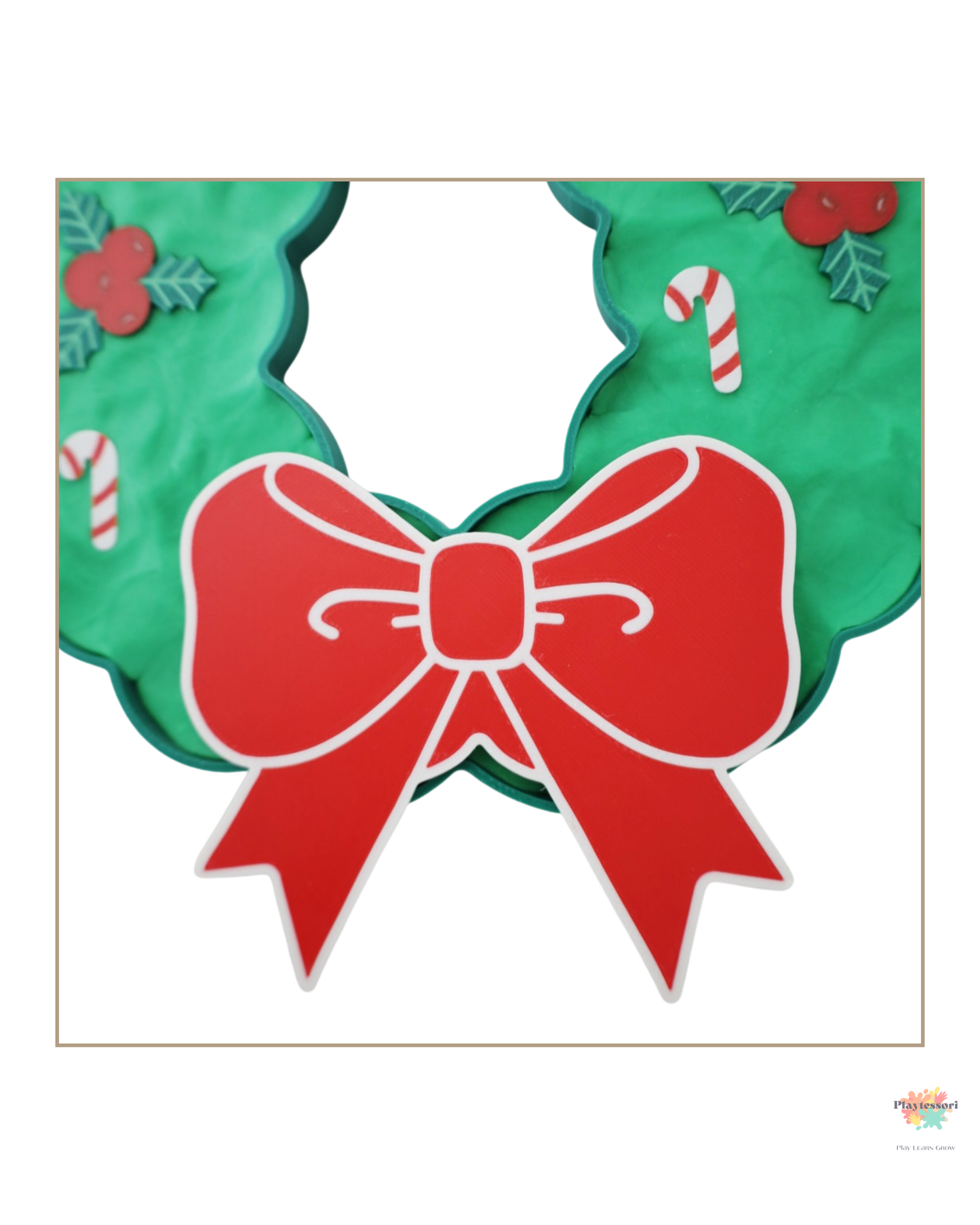 Zbliżenie na czerwoną kokardę świątecznego wianka ułożonego z zielonej masy sensorycznej.