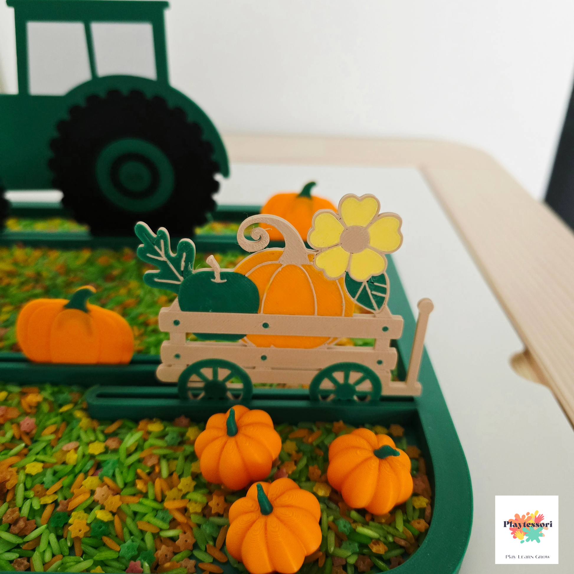 Green farm sensory tray with pumpkins supporting fine motor and imaginative play.