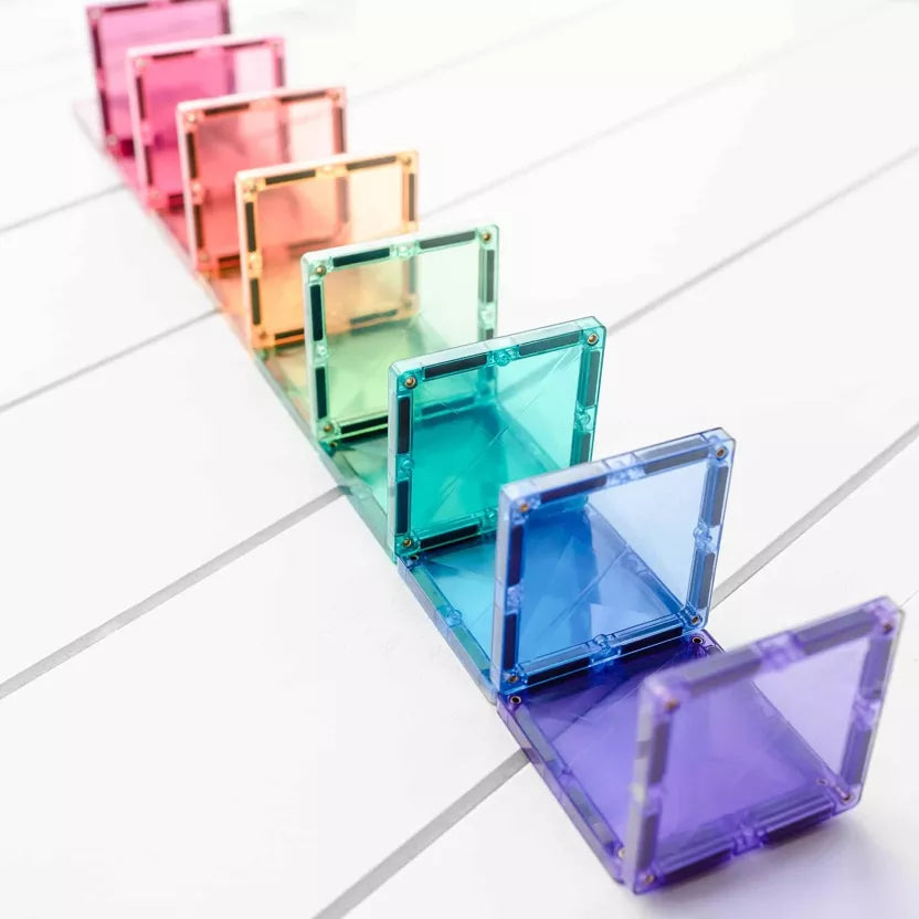 Colorful transparent square blocks arranged in a row on a light gray surface.