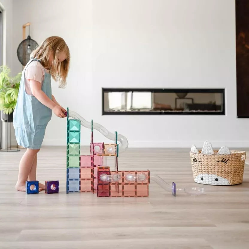 Child playing with colorful building blocks in a room with a fireplace and plant.