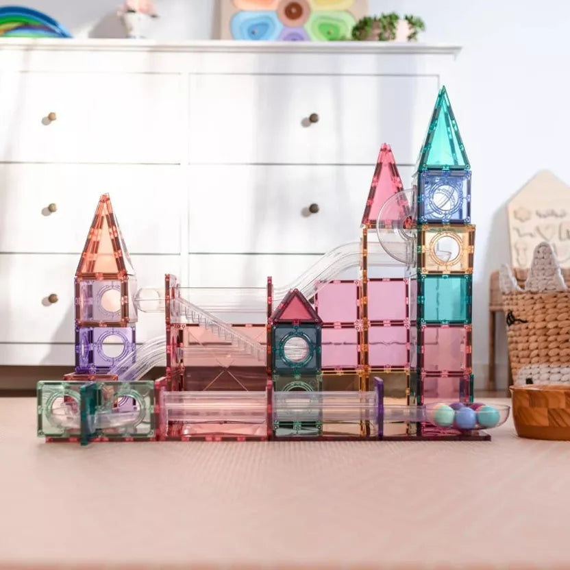 Colorful magnetic building blocks on a table with a white cabinet in the background