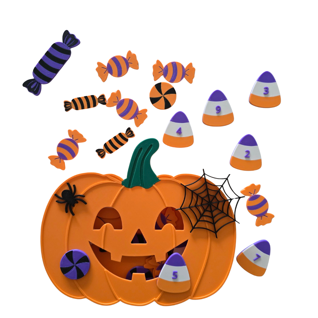 Halloween-themed toy set featuring a carved orange jack-o'-lantern with a green stem, black spider, black web, and scattered candy pieces including striped wrapped candies, purple-and-white candy corn pieces numbered 1 through 9, on a plain white background.