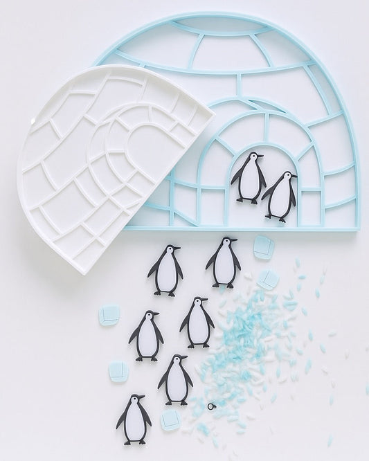 Eco-friendly 3D printed igloo sensory tray with penguins and blue rice for winter-themed sensory play, fine motor learning, and Arctic exploration.