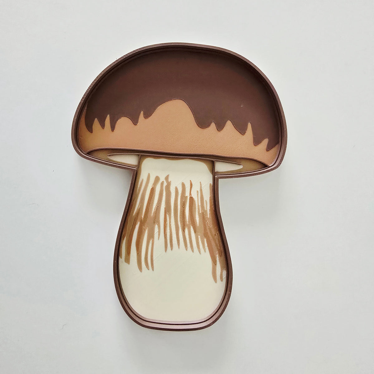 Mushroom sensory tray placed on an open illustrated nature book about fungi and the mushroom life cycle, for Montessori autumn nature study