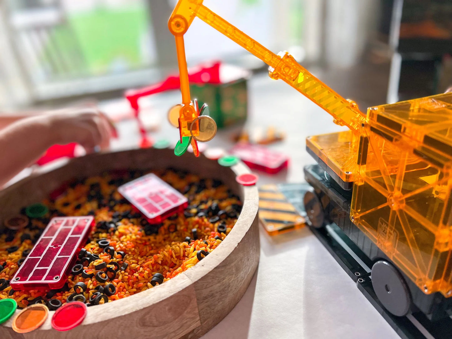 Children's play area with a toy crane and colorful sand pit.