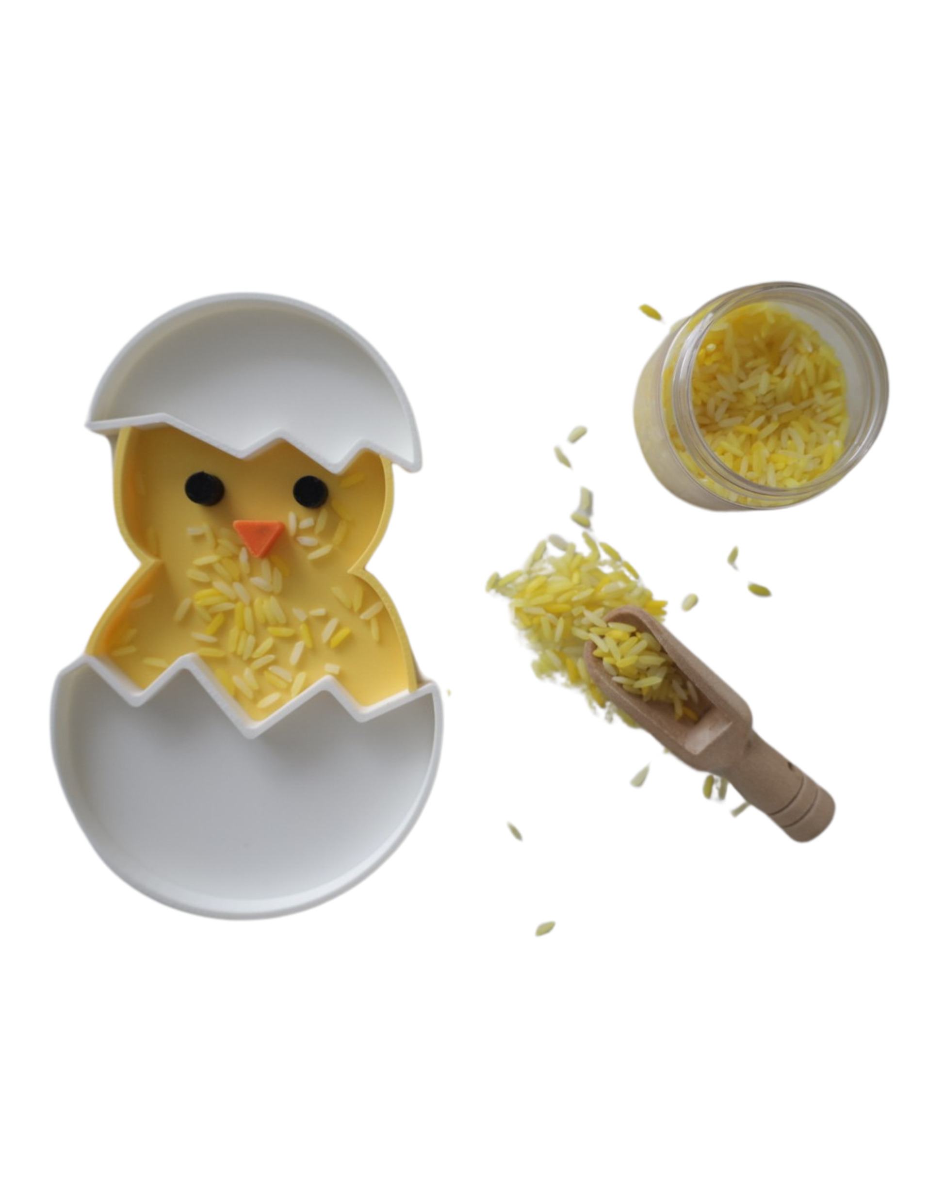 Yellow and white 3D printed chick hatching from egg sensory play tray by PlayTessori, filled with yellow colored rice, shown with wooden scoop and glass jar, Montessori Easter activity for toddlers
