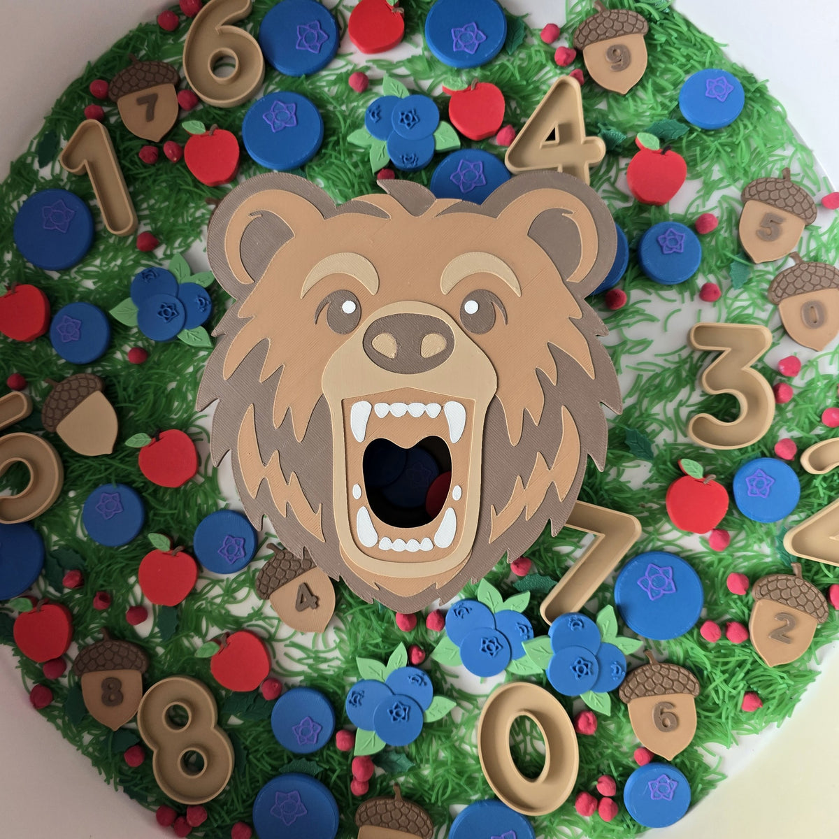Bear feeding set with number cut-outs 0-9 in a green sensory bin
