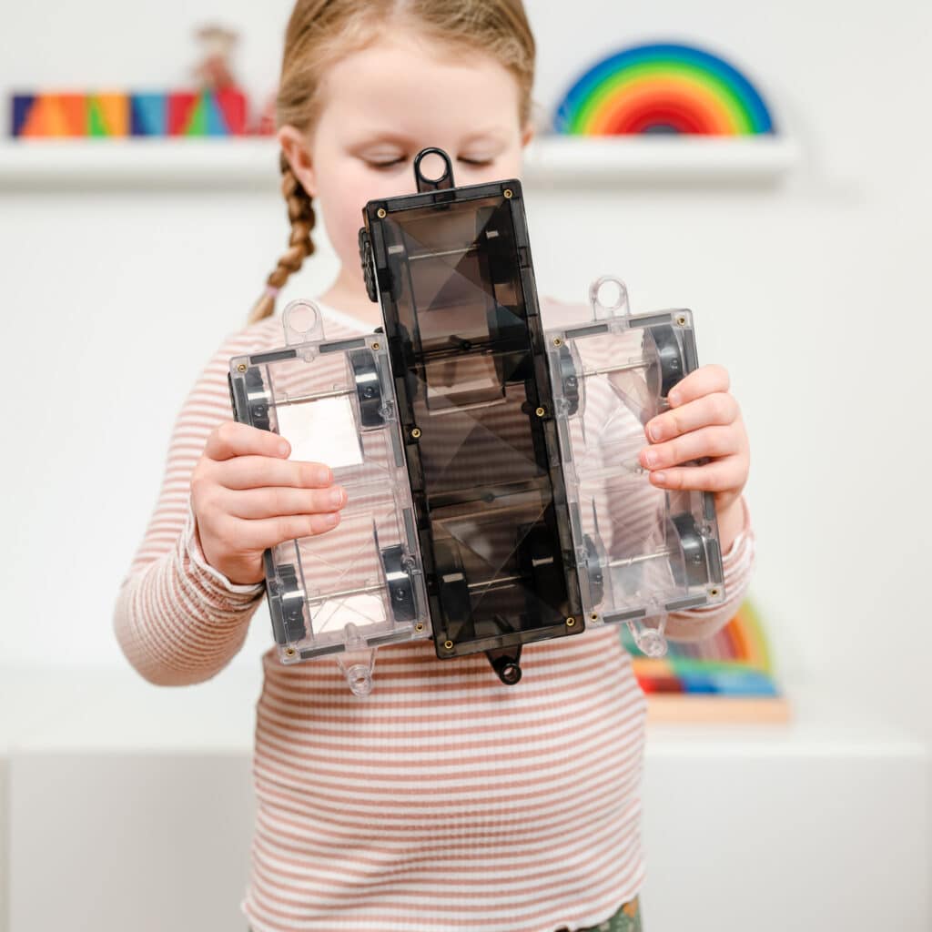 Child holding a transparent solar panel in a classroom setting